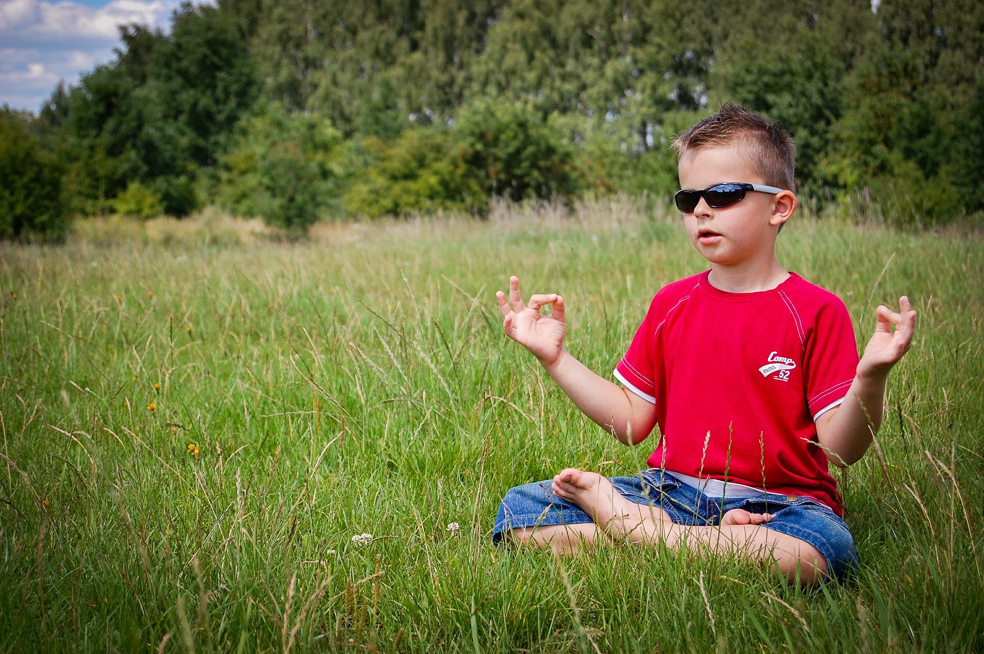 boy meditating in field