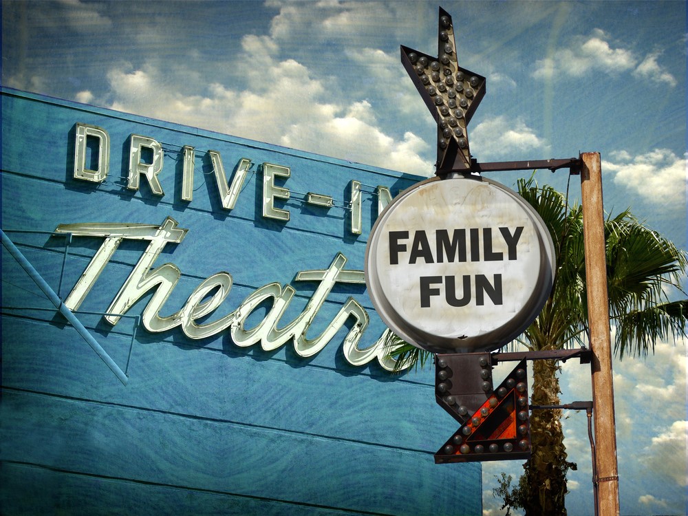 Aged and worn vintage photo of drive in movies sign