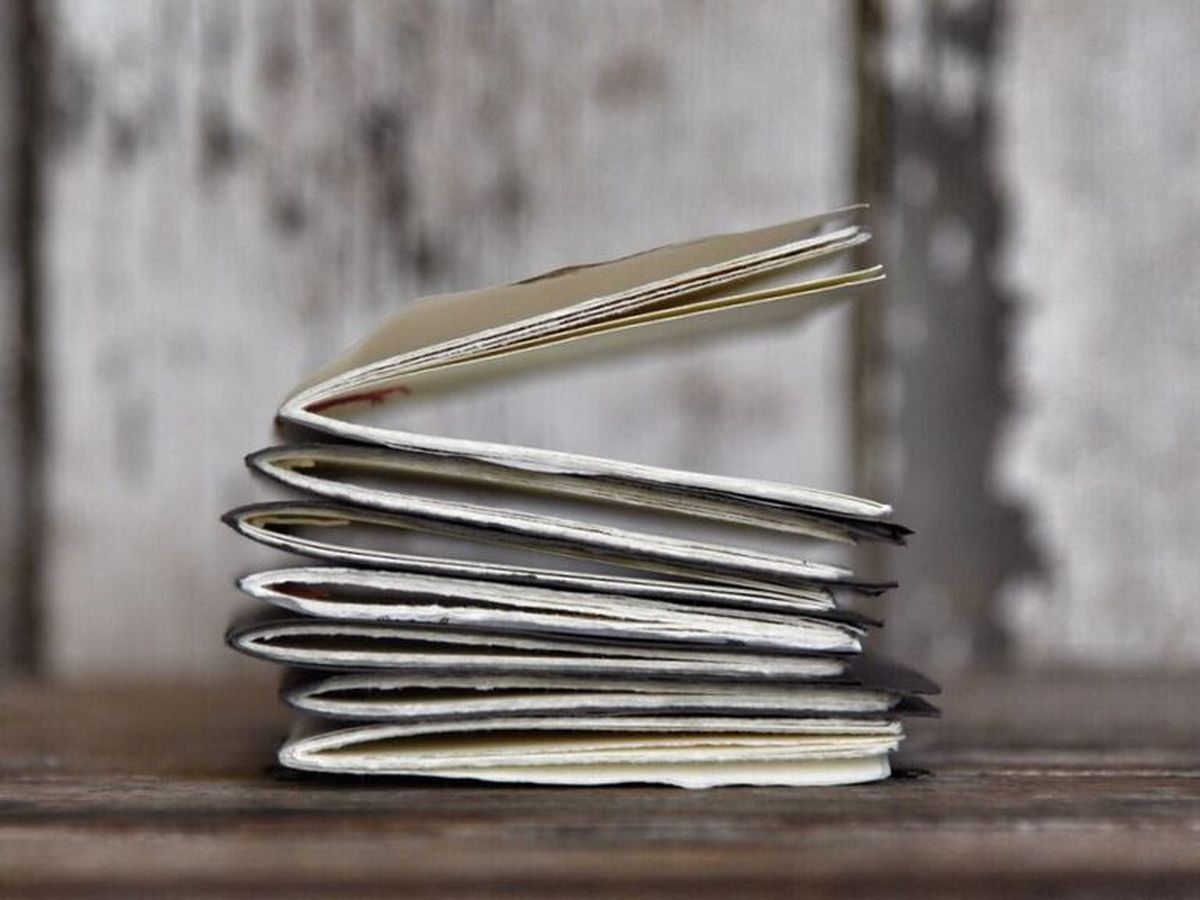 A stack of baby journals that have been sewn by hand