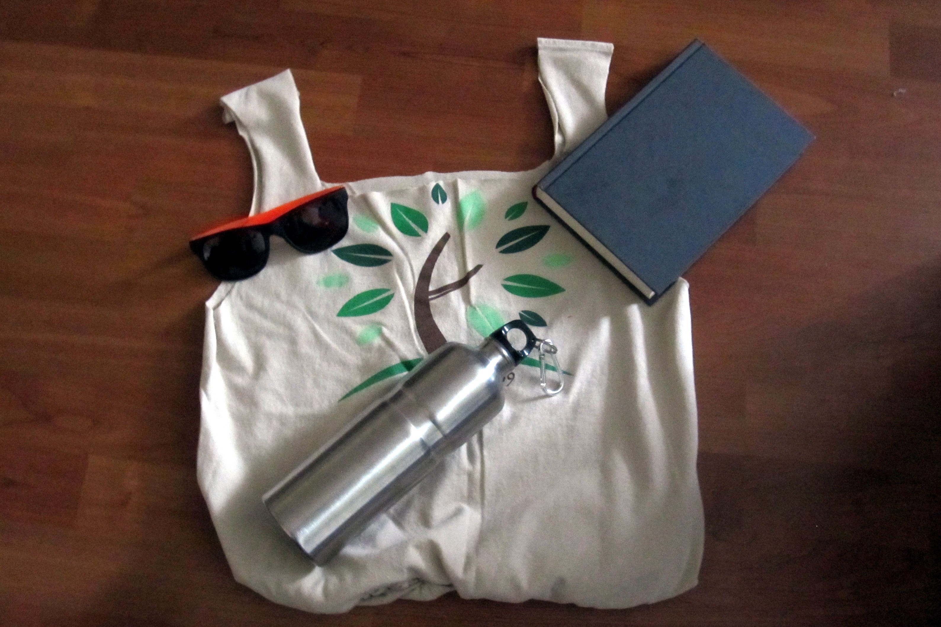 t-shirt bag, sunglasses, water bottle, and book
