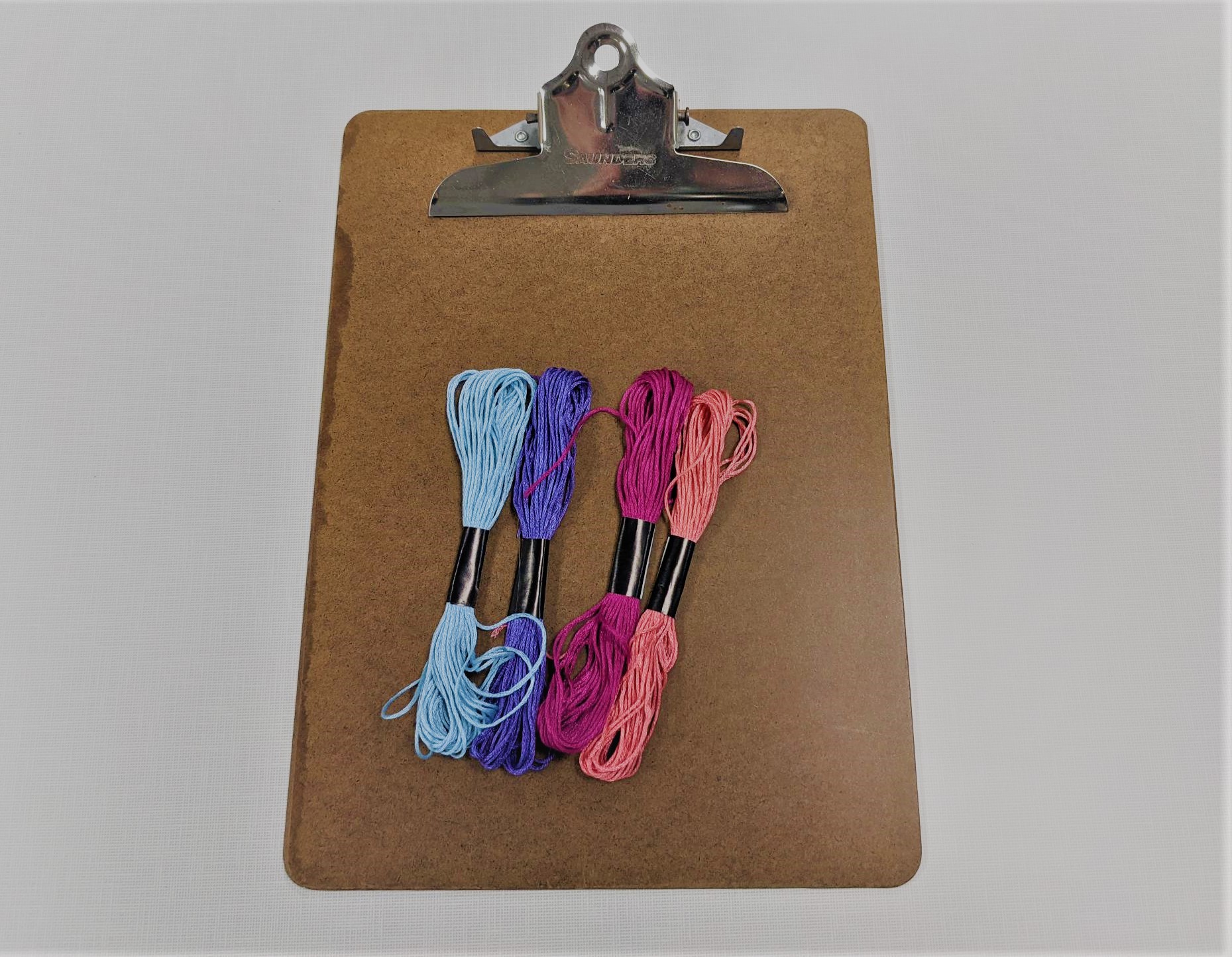 colored skeins of thread on clipboard
