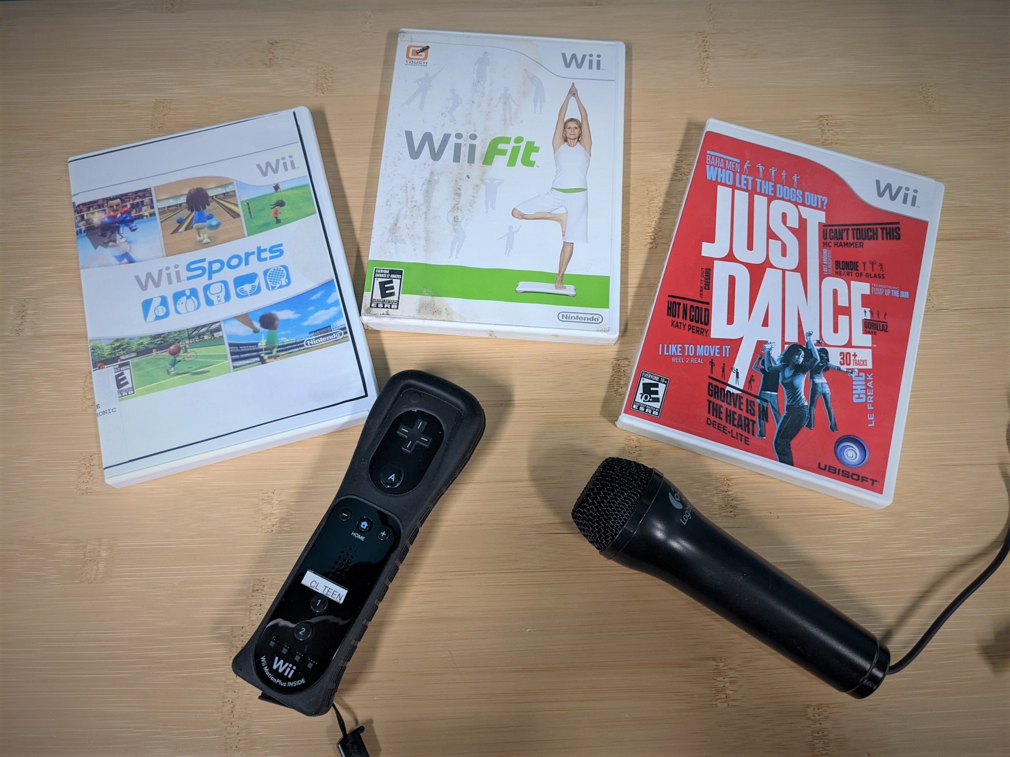 Wii Sports case, Will Fit case, Just Dance Wii case, Wii mote, and Wii karaoke microphone
