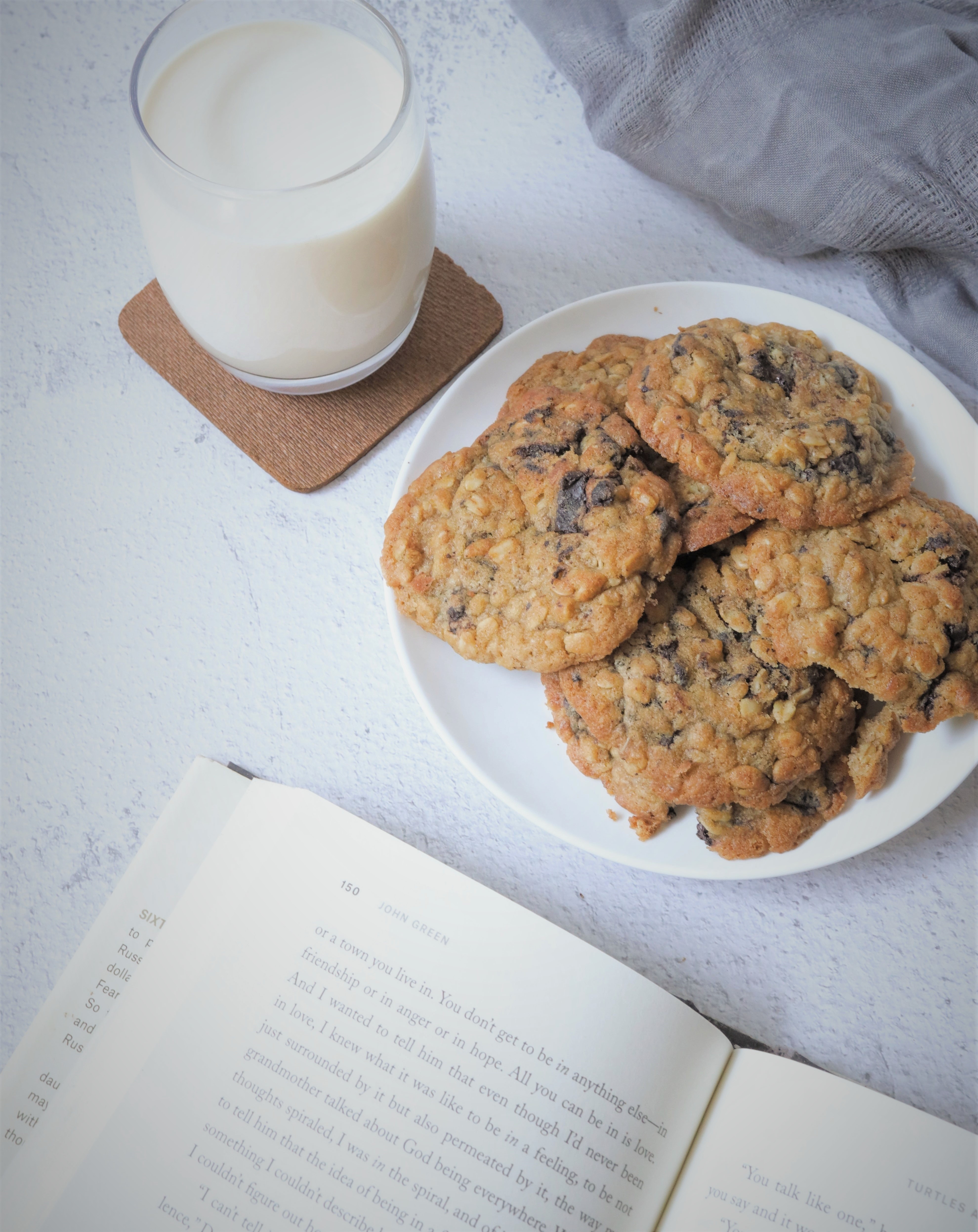 opened book, glass of milk, plate of cookies
