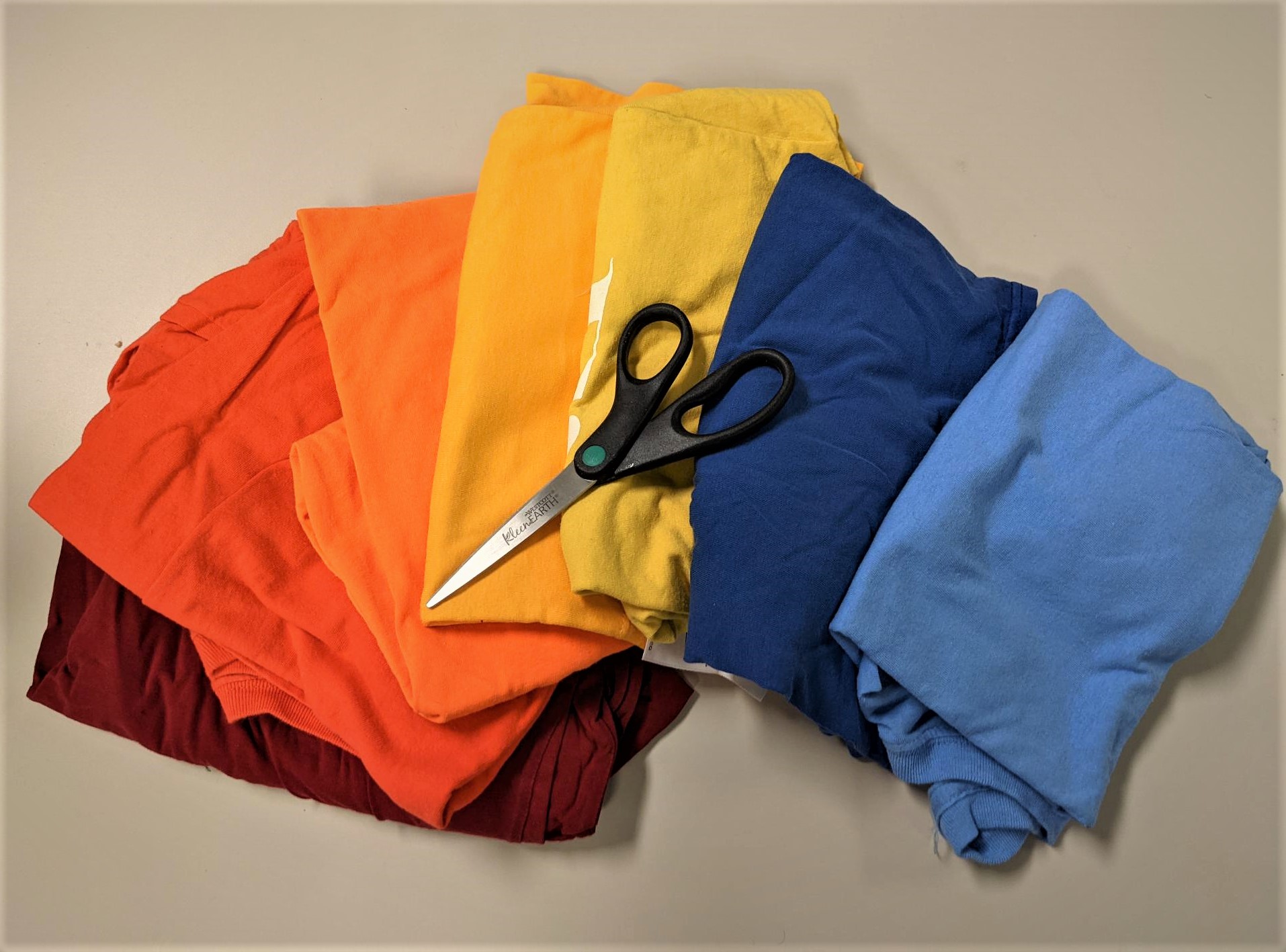 different colored t-shirts and a scissor