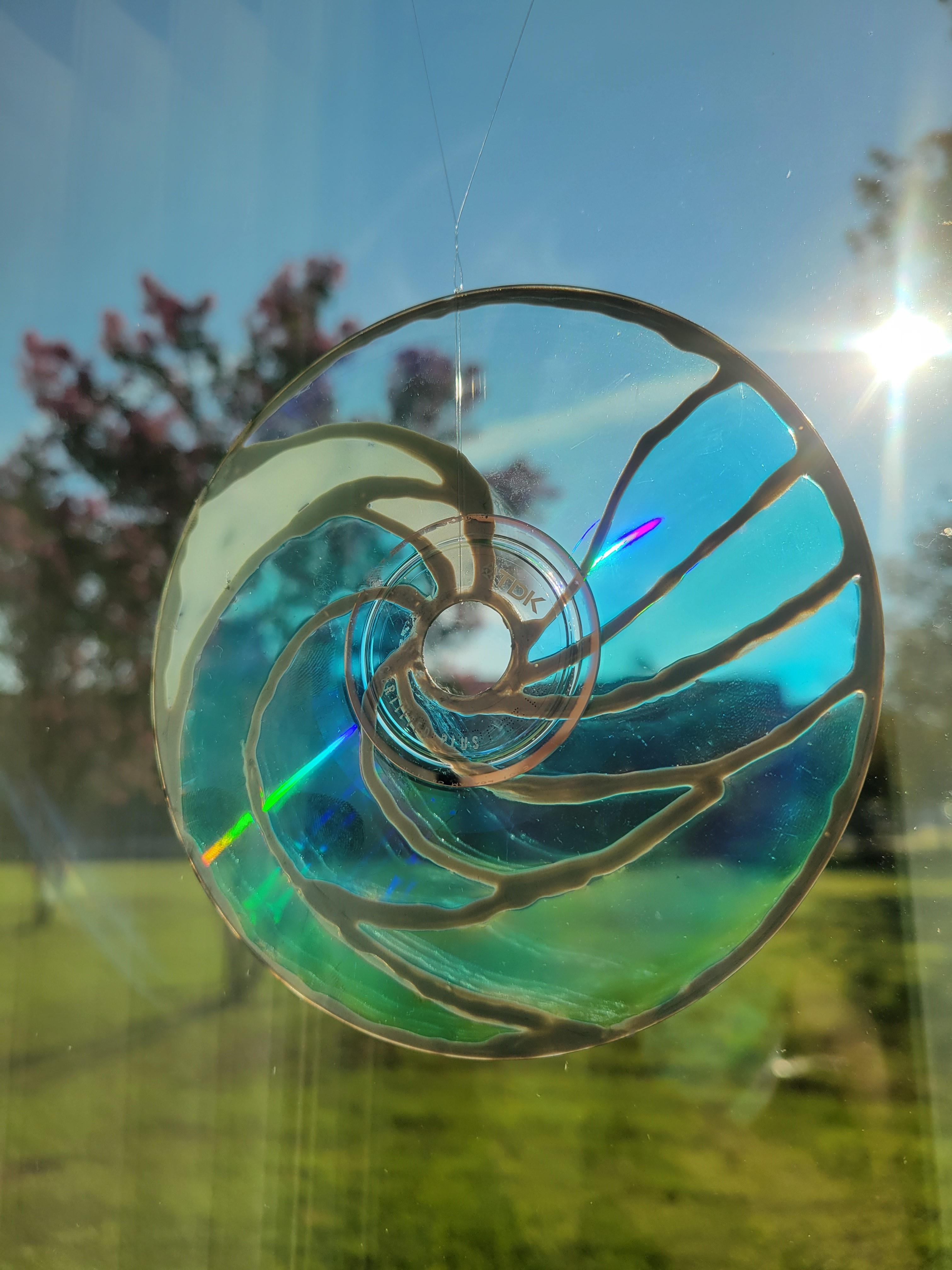 A circular suncatcher resembling a wave