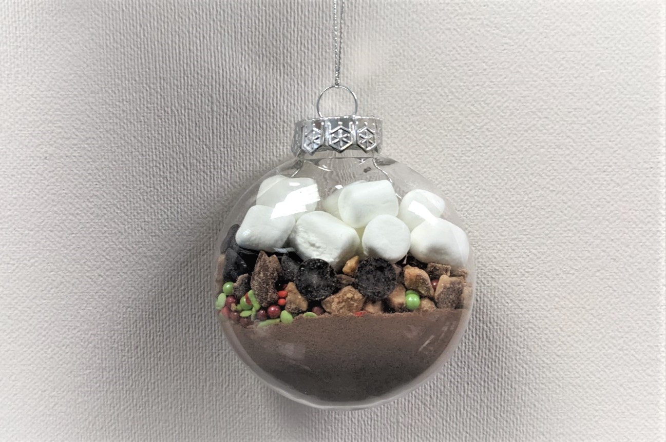 clear ornament ball with cocoa mix, sprinkles, chocolate bits, and mini marshmallows