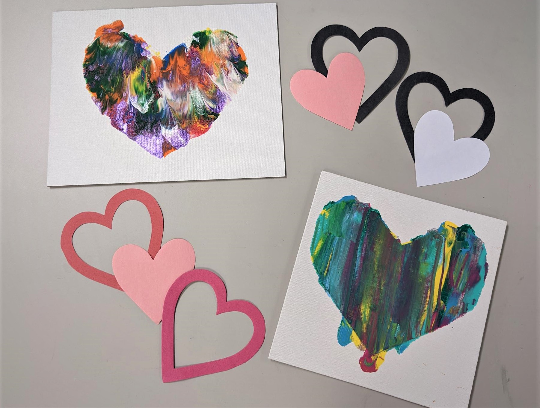 2 painted heart canvases with heart cut-outs