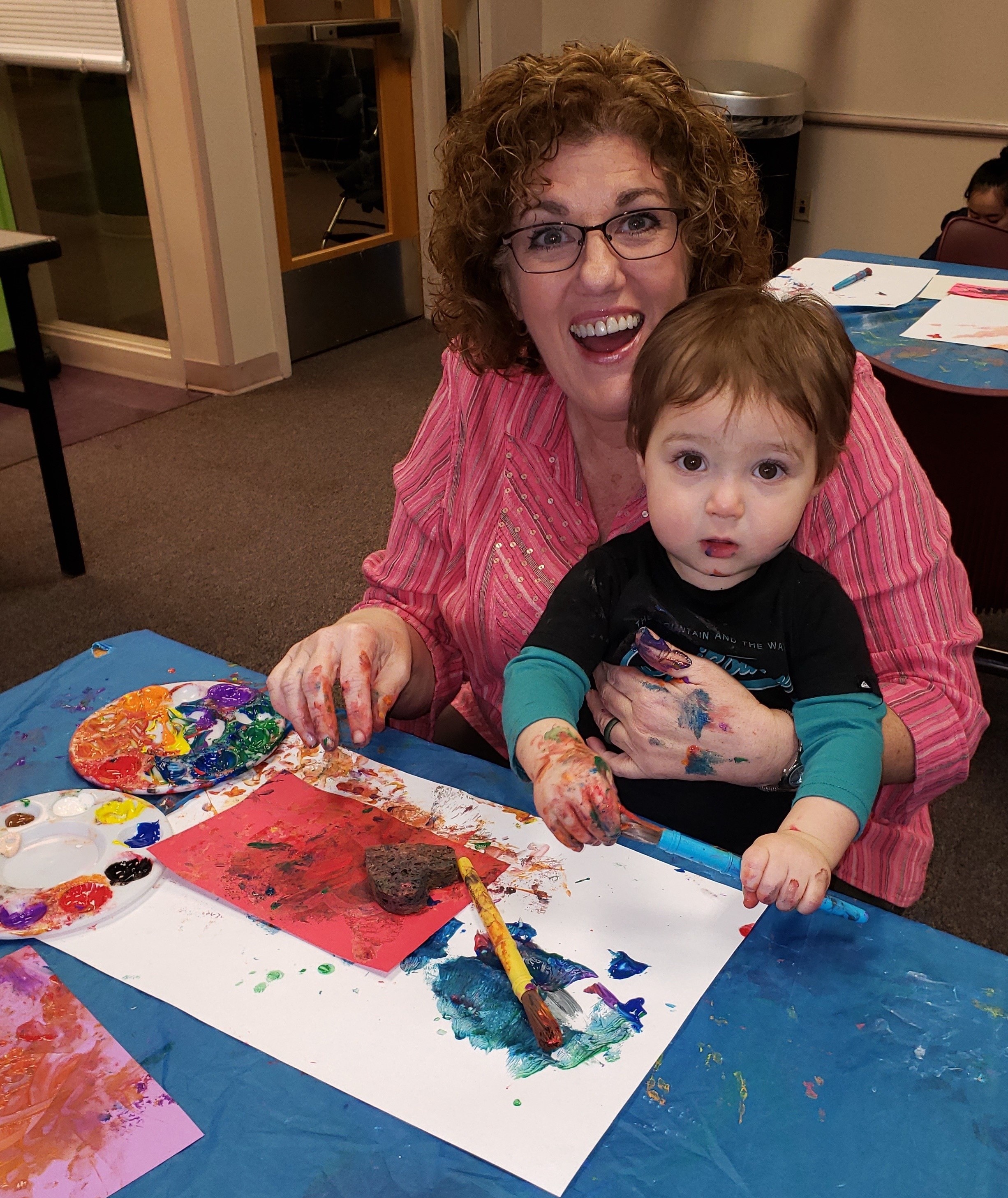 toddler and caregiver painting messy