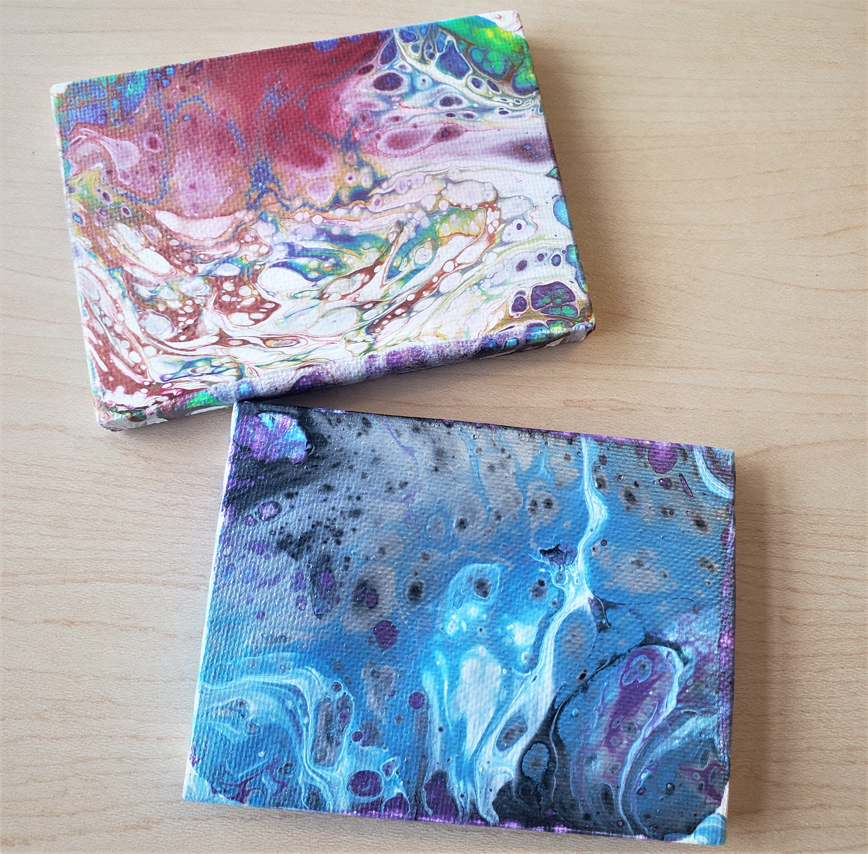 mini canvas with rainbow paint pouring and second mini canvas with cool paint pouring colors
