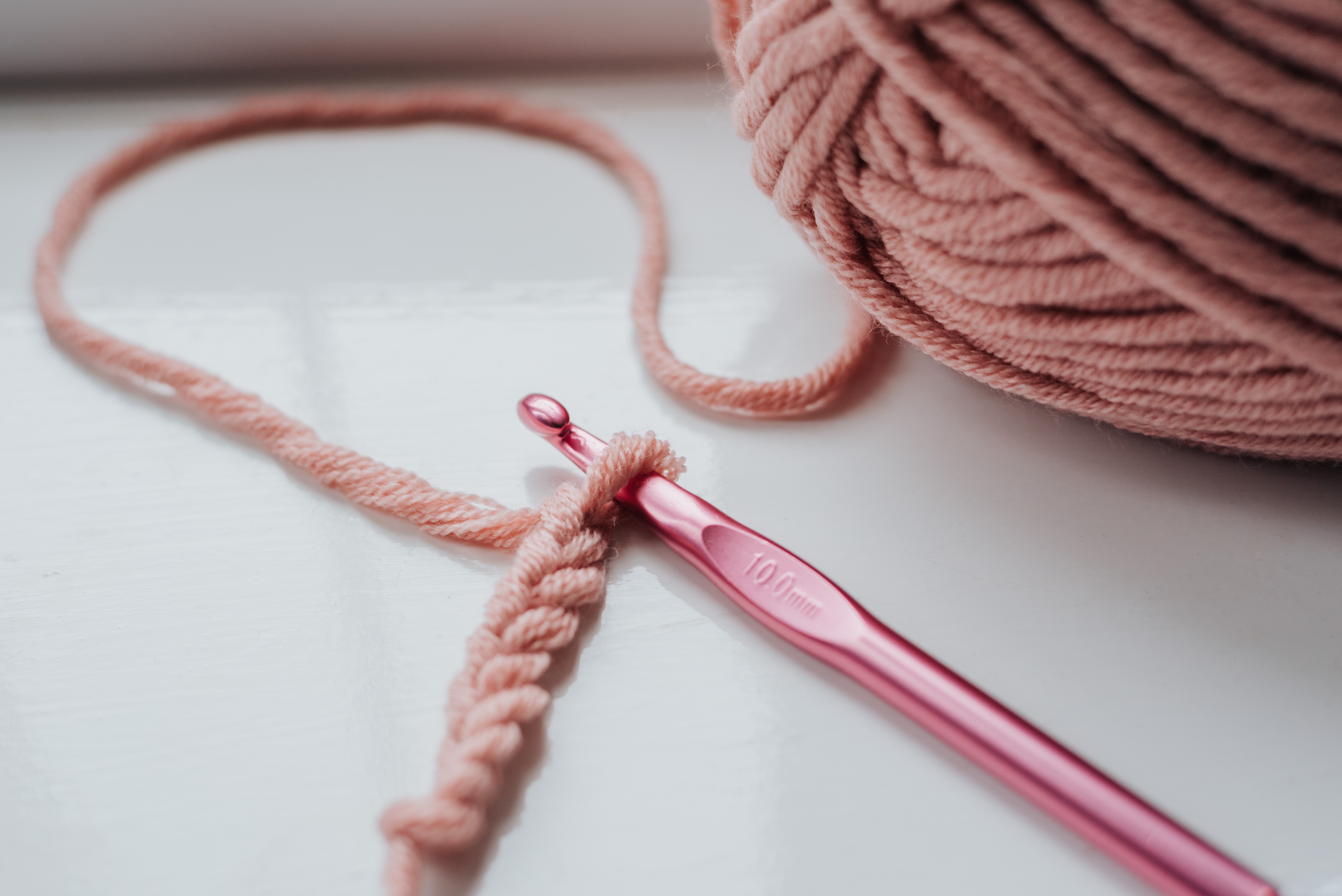 pink yarn and pink crochet hook