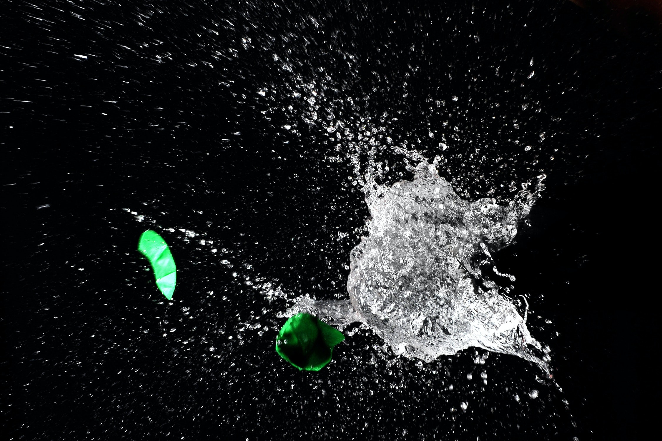 broken green water balloon and splash of water