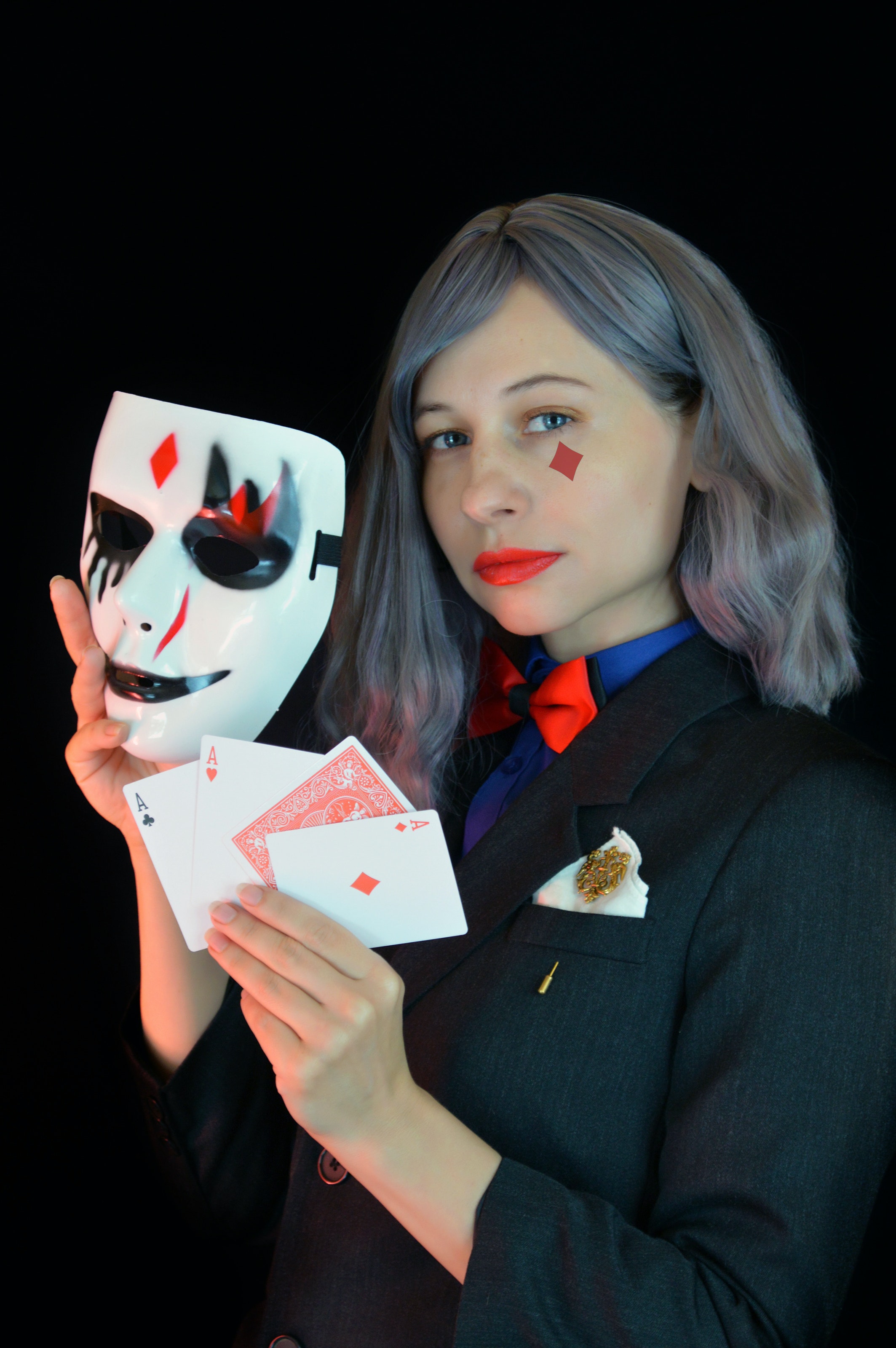 girl in black holding a mask and cards