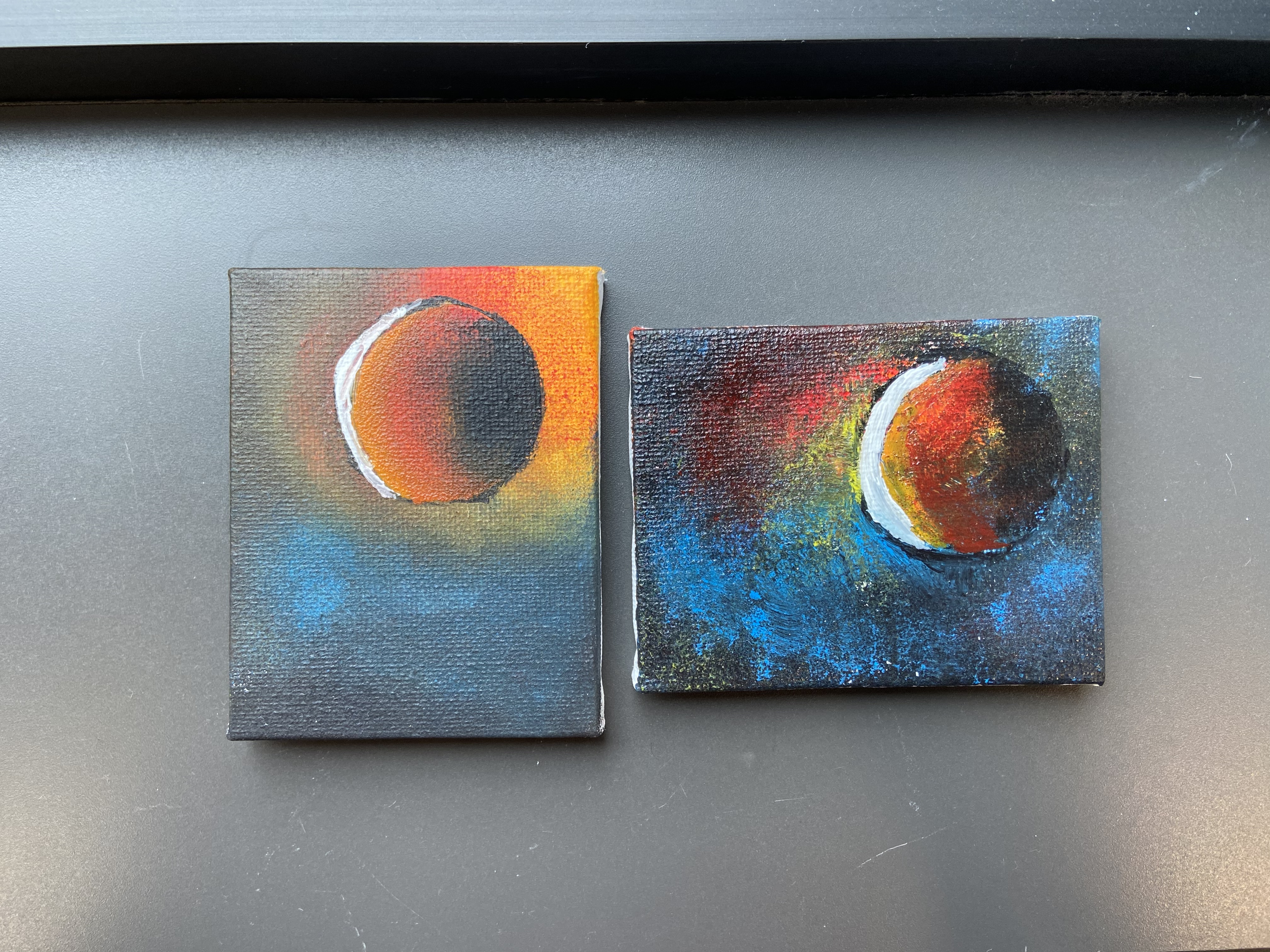 Two eclipse paintings over a black background.