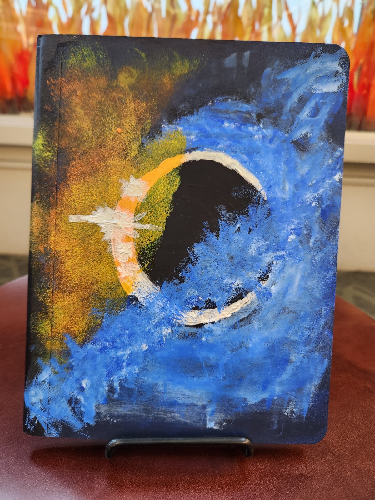 Sample of decorated notebook with painted eclipse.