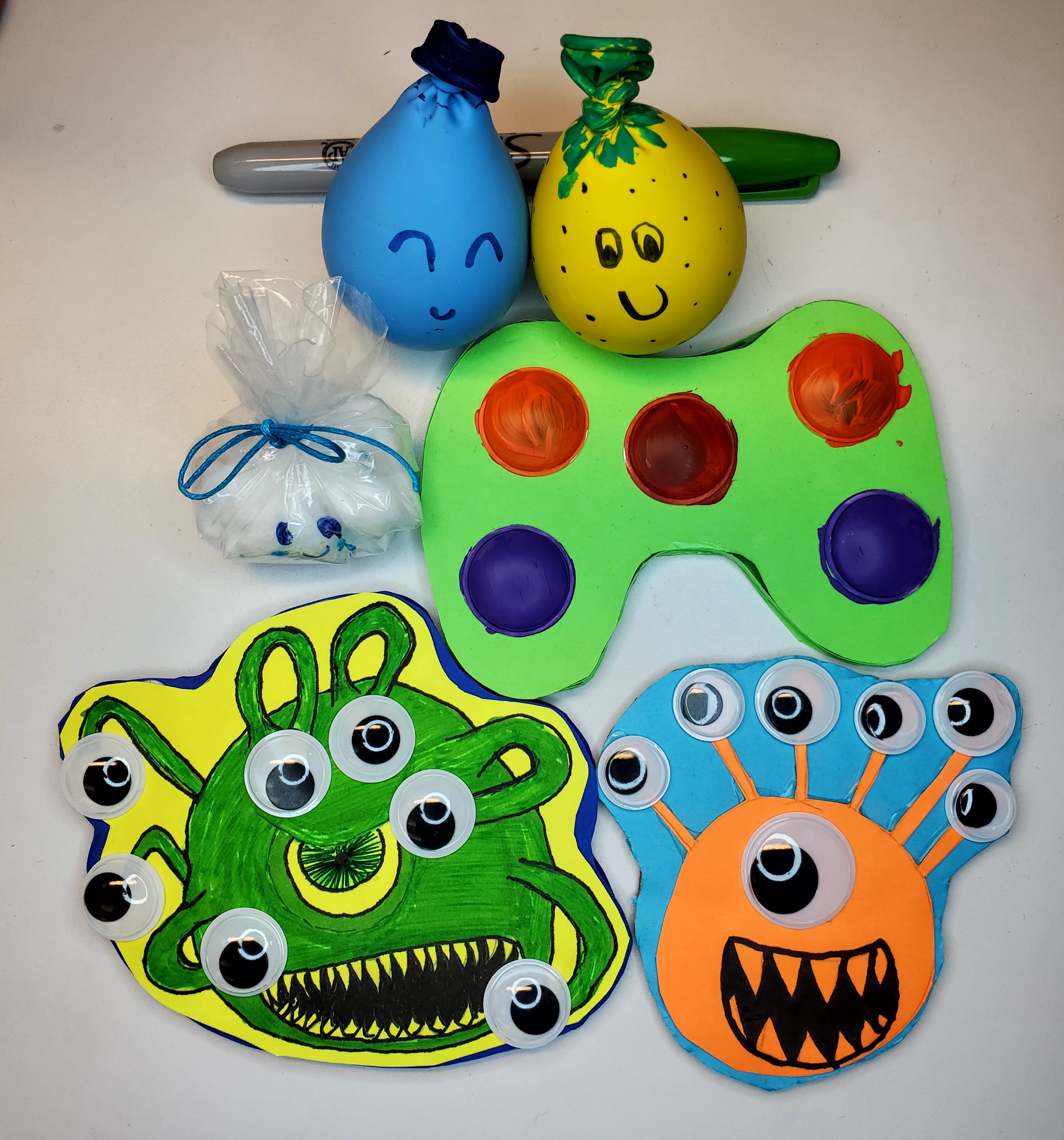 Six fidget toys: a colorful videogame controller pop-it, a cute beholder pop-it, a scary beholder pop-it, a cloud squishy, and two slime balloon squishies