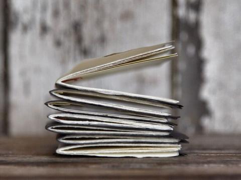 A stack of baby journals that have been sewn by hand