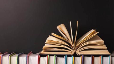 Photo of an open book on top of a row of books