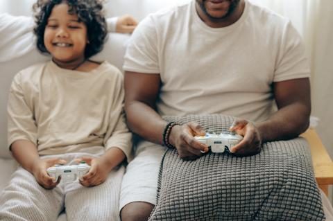 Child playing videogames with father 