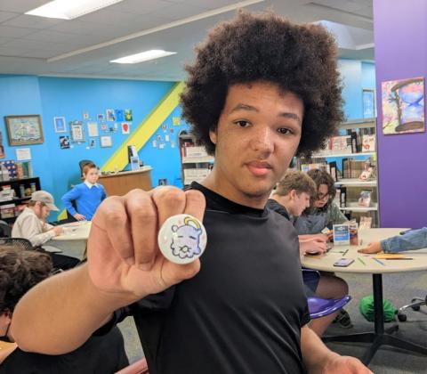 teen boy holding a button