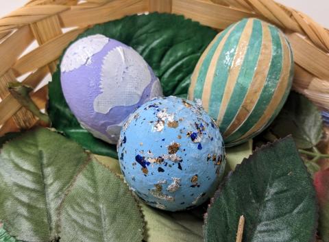 lavender colored egg with doily decoupage, speckled light blue egg, and striped green and yellow egg 
