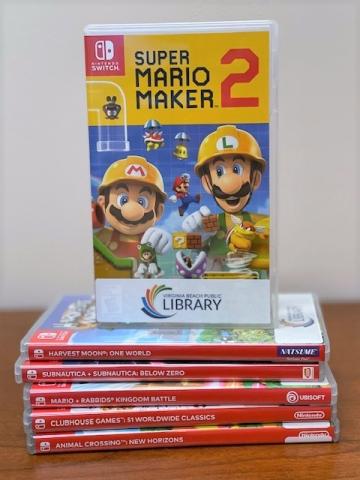 Super Mario Maker 2 is displayed on a stack of Nintendo Switch games.