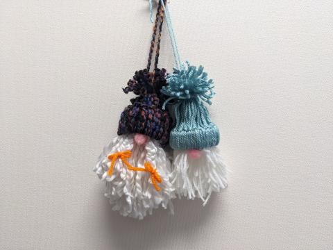 2 yarn gnome ornament (one with a multi color hat and braids and one with a teal hat)