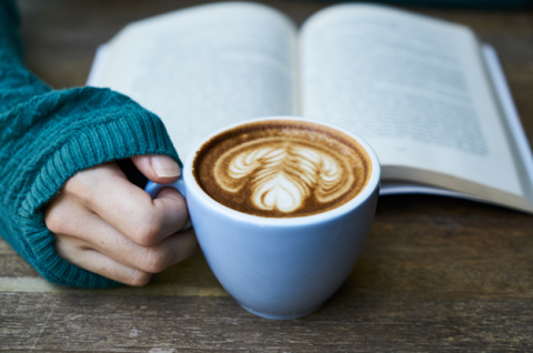 Mug of coffee and open book