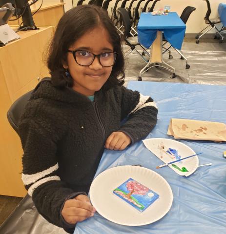 Girl and her artwork on a tiny canvas.