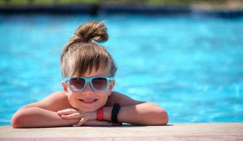 Happy child girl relaxing swimming pool side sunny summer