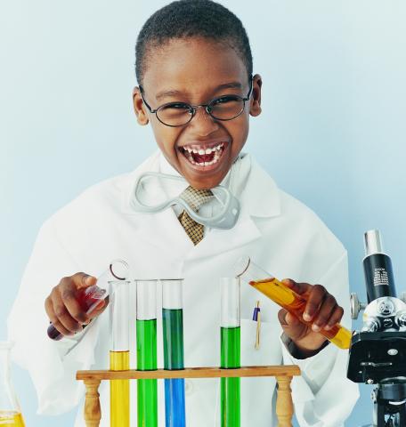 child in lab coat with test tubes