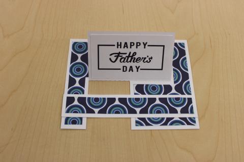 Happy Father's Day text. Glue green and white decoration on a white greeting card base.
