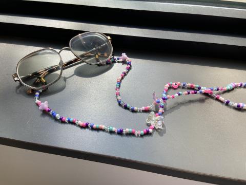 Glasses with a colorful beaded chain. 
