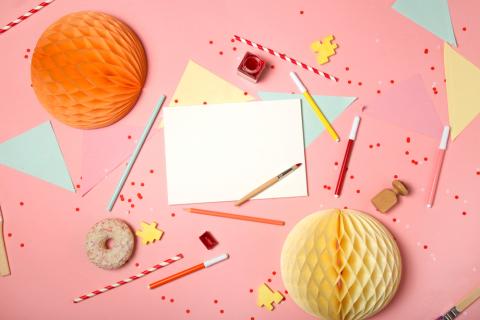 colorful pink background with party confetti paper decoration stationary DIY supplies art accessories brushes and stamp with paper card