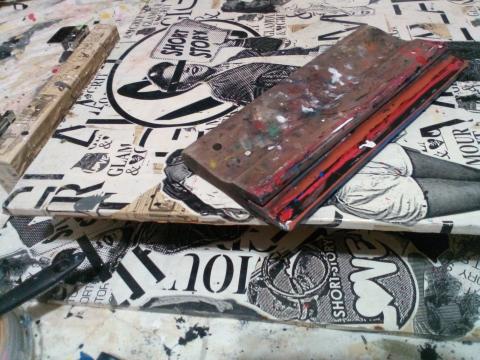 Screen printing squeegee laying on top of original screen print by Short Story