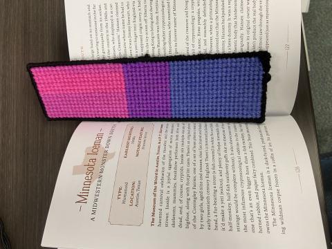 A woven bookmark with the bisexual flag colors.