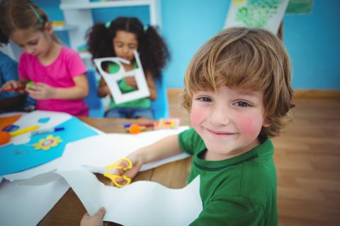 child smiling doing arts & crafts