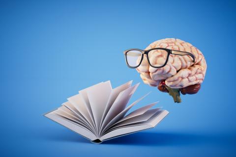 A floating brain wearing glasses and reading a book