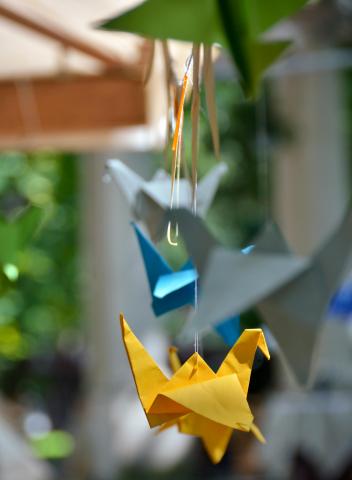 yellow origami crane hanging with a blue crane behind