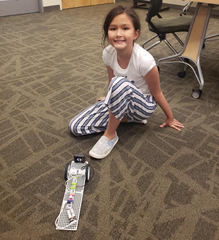 Teen girl on floor playing with LittleBits.