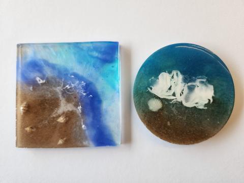 Resin coasters decorated with sand, shell, and color.