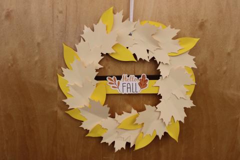 cream colored and yellow paper autumn wreath hanging on door