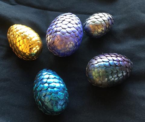 Sample of dragon eggs made out of Styrofoam and thumb tacks, some painted and one unpainted.