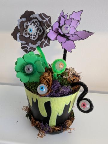 Fake Plant with eyeballs, in a black pot with moss and painted on slime.