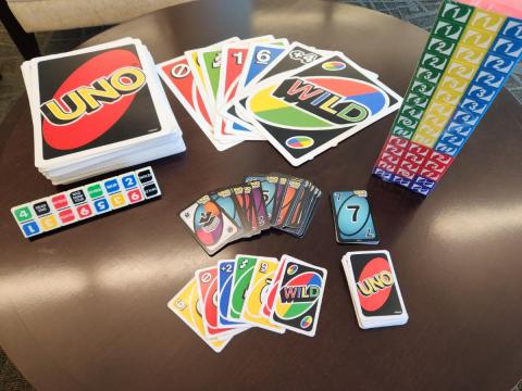 Table with various UNO games: jumbo, dominoes, stack-o, and cards.