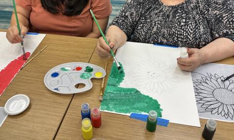 two women painting together at a table