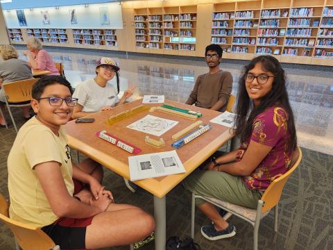 Group of teens playing Mahjong.