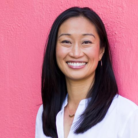 Nicole Chen standing in front of pink wall. 