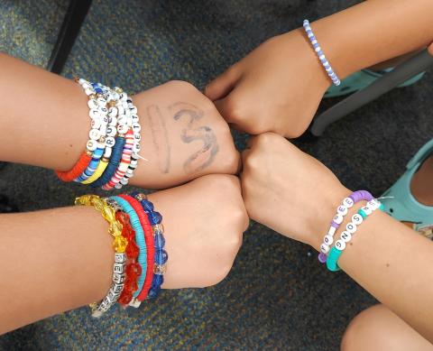 4 arms wearing friendship bracelets