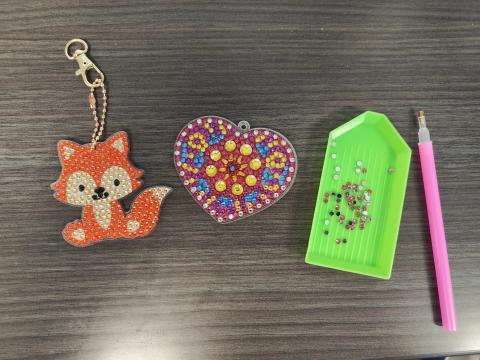fox keychain, heart keychain, green tray of diamond drill bits, and pink stylus