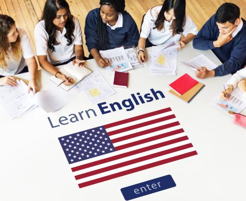 Learn English Enter words with United States flag on tabletop; group of people studying at the table